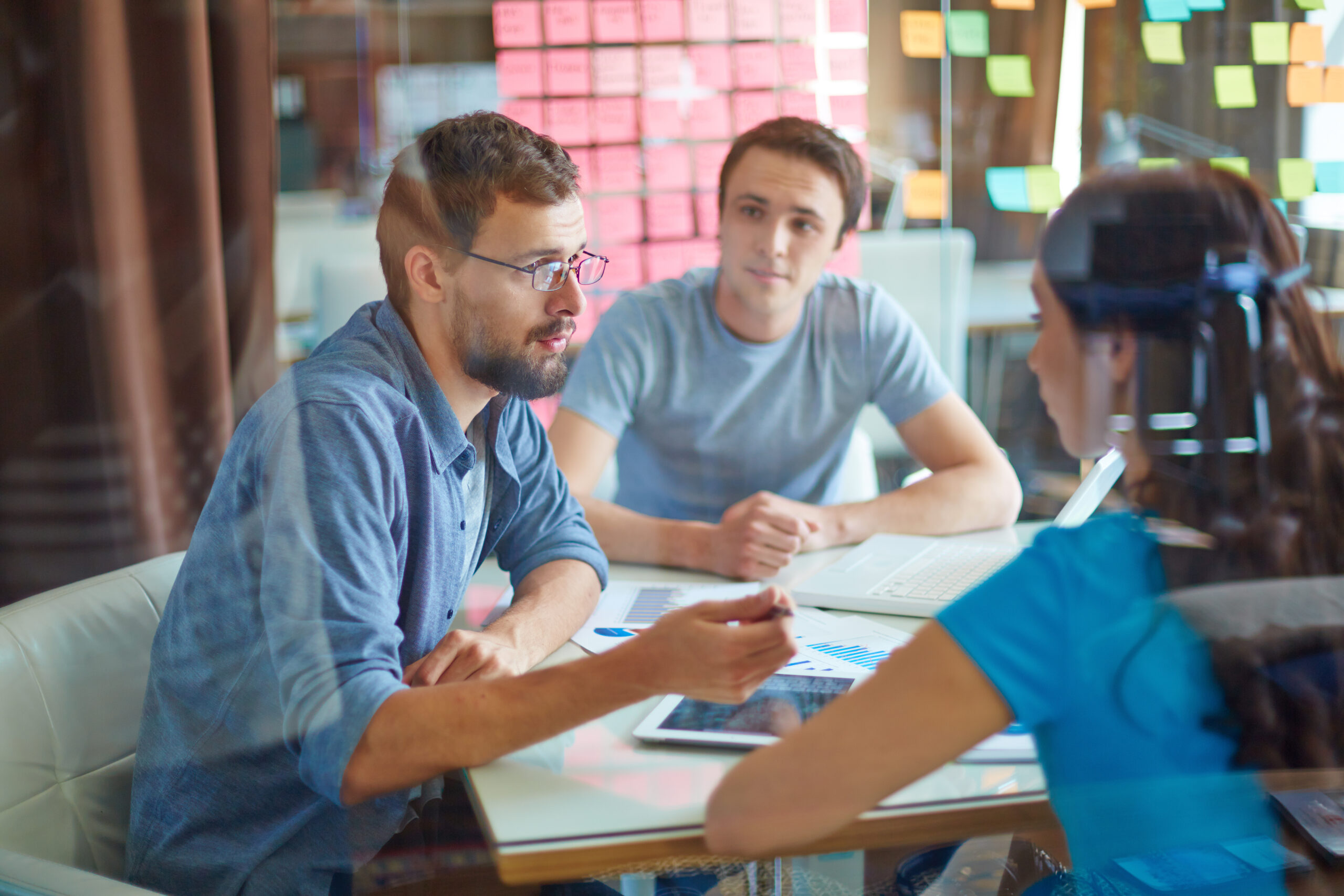 Young man consulting his business partner at meeting in office